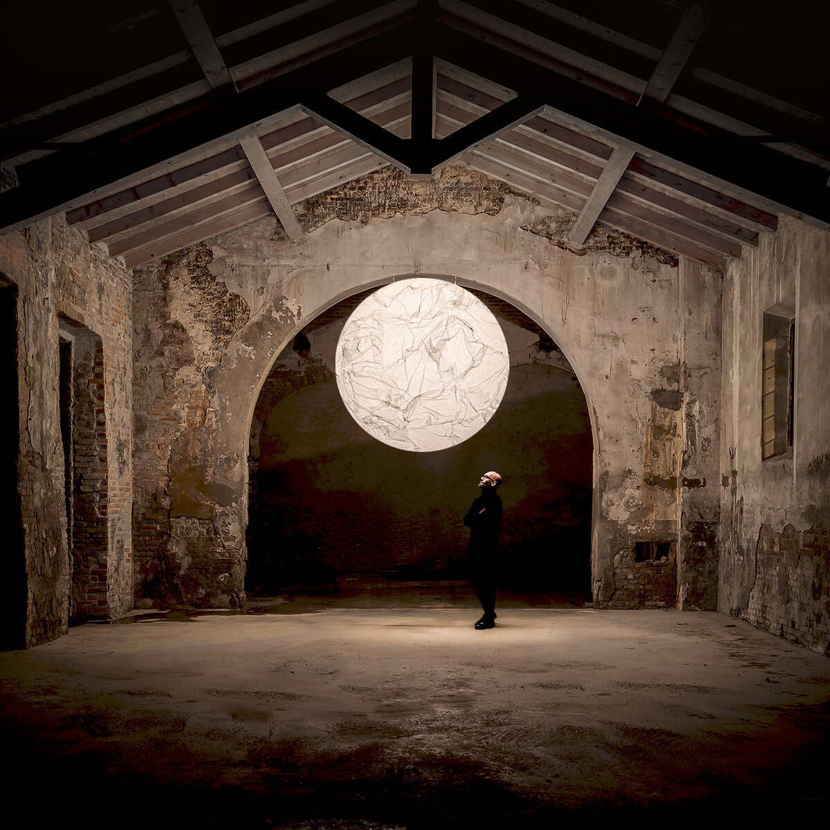 直徑200公分的Moon高掛在室內建築中，底下有一個人站立望著
